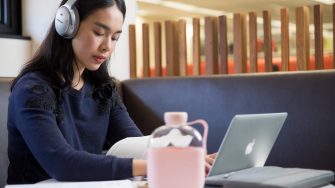 Student studying with headphones and laptop