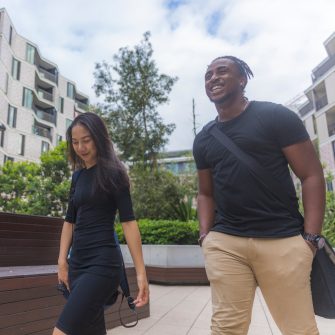 Male and female student walking outside near on campus accommodation