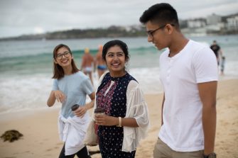 Students walking in sand at Bondi beach