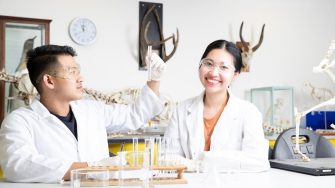Students in Science Lab with white lab coat doing experiments