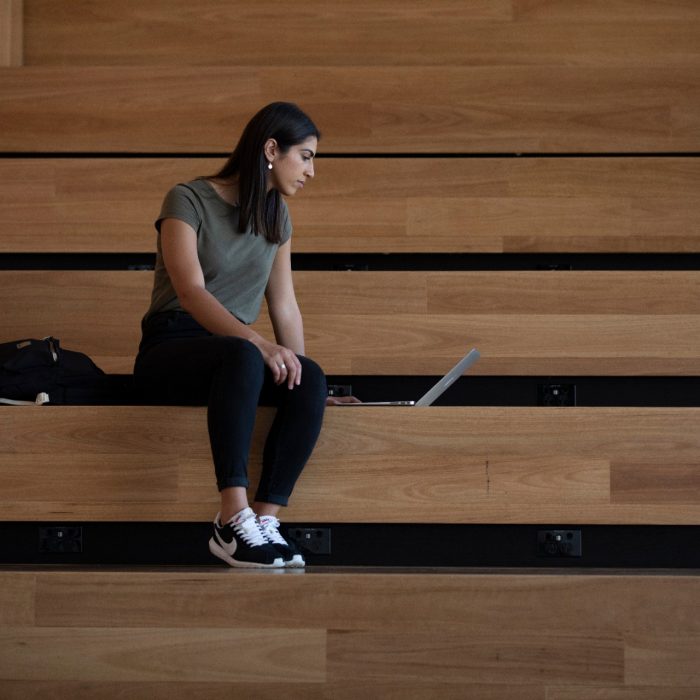 Students sitting on brown wooden steps