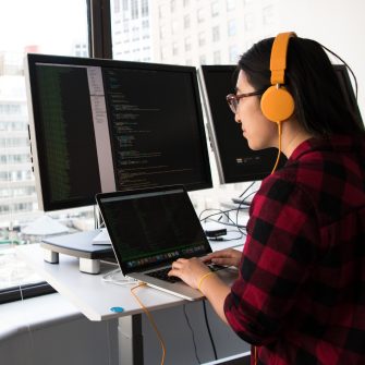 Software developer at computer wearing headphones