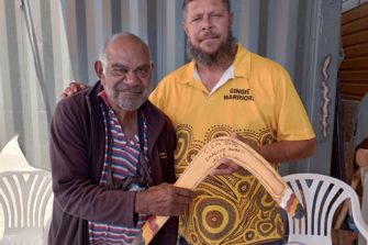 Dharriwaa Elders Group Speaker Clem Dodd being presented with a bubarra (fighting boomerang) made by Dealing with Fines Coordinator Stephen 'Bungee' Dennis in honour of receiving the outstanding lifetime achievement award from the Aboriginal Culture Heritage & Arts Association