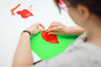 A person creating colourful artwork