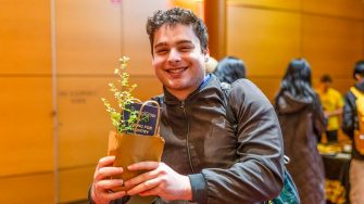 A smiling attendee holds a small potted plant at UNSW Employability’s Careers with Impact 2026.