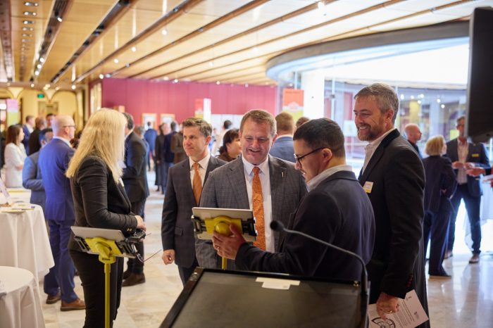 Dr James Dunn (front) takes MP Clayton Barr and UNSW Vice-Chancellor and President Professor Attila Brungs through an AI image detection test..