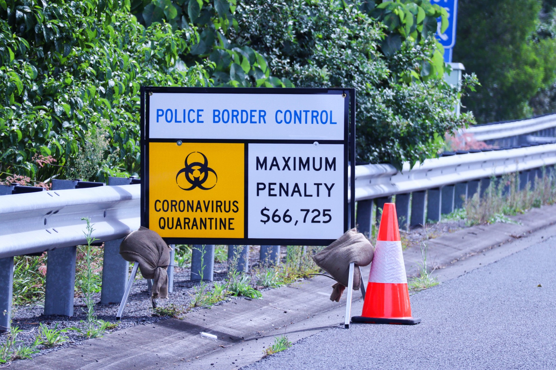 Police control covid warning sign on shoulder of roadway