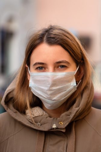 Woman wearing a face mask and jacket
