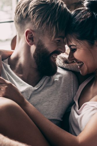 Young couple smiling and sitting face to face in chair 