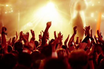 cheering crowd in front of bright yellow stage lights