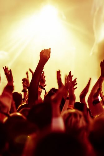 cheering crowd in front of bright yellow stage lights