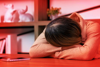 person resting head on desk