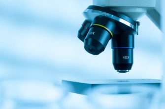 A close up photograph of a microscope in a lab