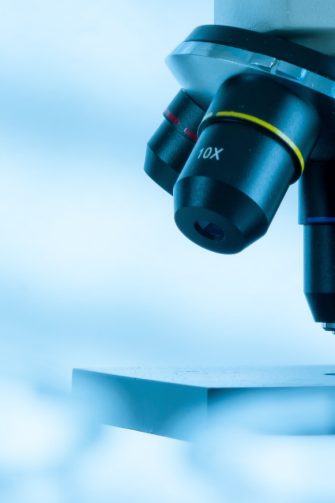 A close up photograph of a microscope in a lab