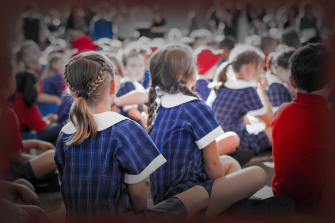 school children with their backs to the photographer, sitting in a group