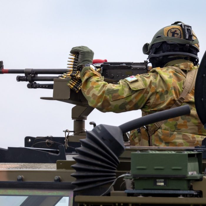 Avalon, Australia - February 27, 2015: Australian Army soldier with large machine gun in the turret of a Bushmaster armoured Personnel carrier (APC).