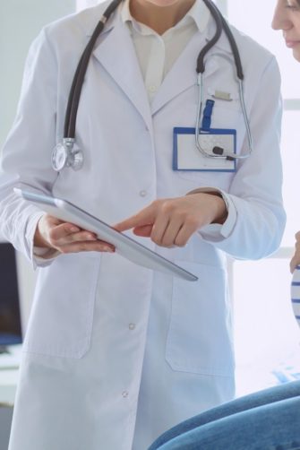 Happy lesbian couple playing with their children at home. Beautiful family of four having great time together indoors.