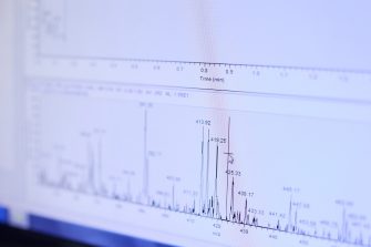 Laura Capasso, William Alexander Donald and Merryn Baker looking at equipment that analyses breath samples for early detection of silicosis in a lab in School of Chemistry