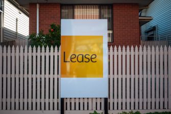 An advertisement sign for a residential property and suburban house listed for lease. Concept of the housing market, real estate, and renting a home.