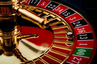 close view of the ball sitting in the black 13 slot of a roulette wheel