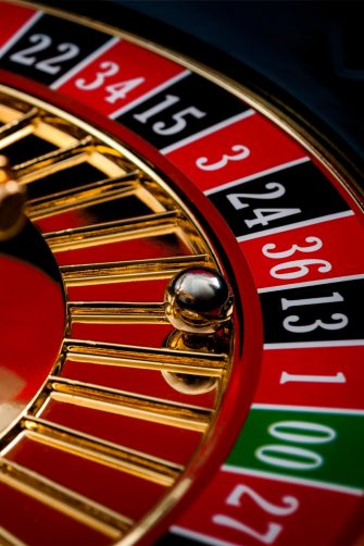 close view of the ball sitting in the black 13 slot of a roulette wheel