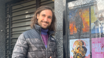 James Dutton stands in front of French language movie posters.