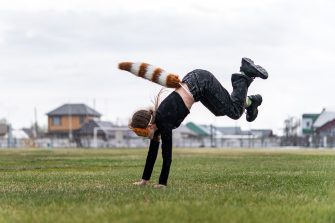 Teenage girl with cat mask and gloves doing Quadrobics. A girl in a cat mask Jumps like a cat