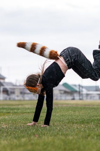 Teenage girl with cat mask and gloves doing Quadrobics. A girl in a cat mask Jumps like a cat