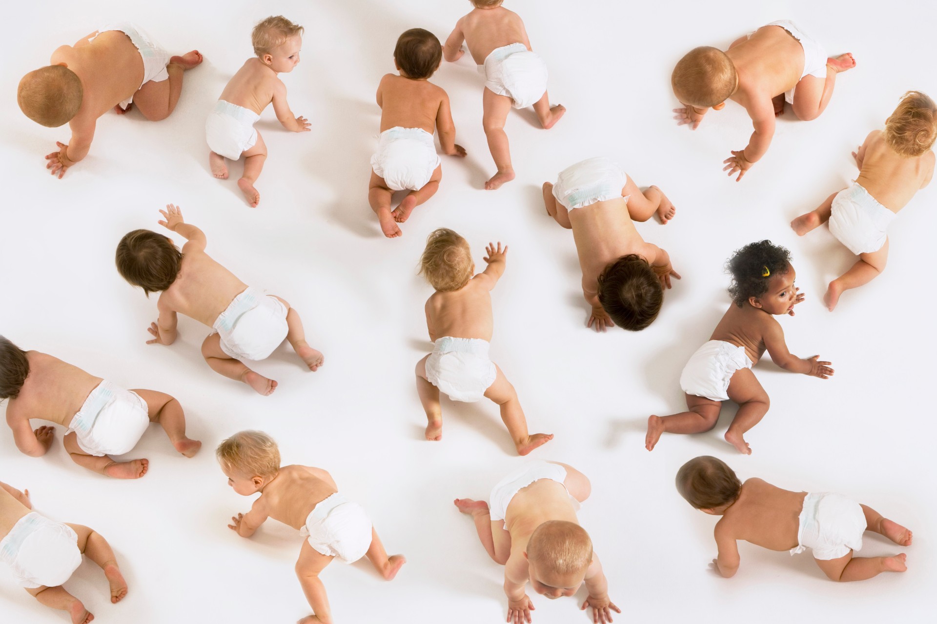 Group of multiethnic babies crawling isolated on white background