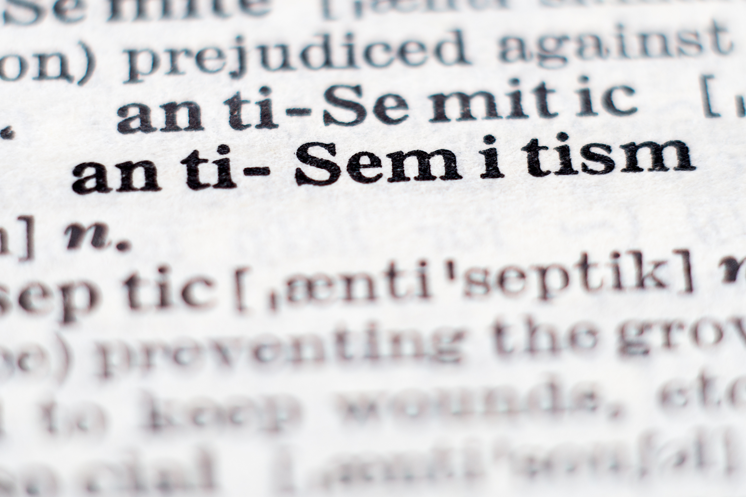 Dictionary definition of word antisemitism, selective focus.