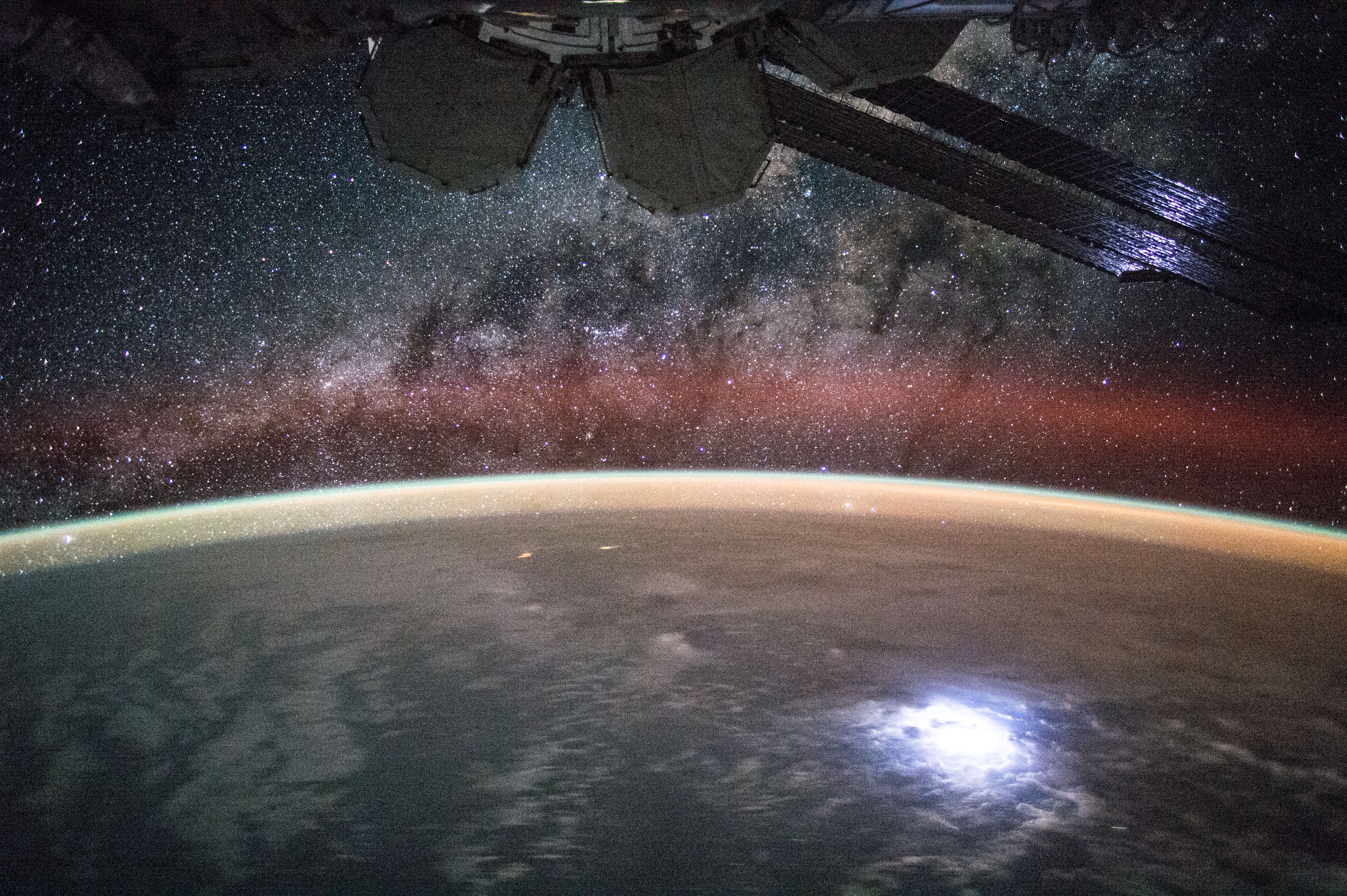 iss044e045215 (08/09/2015)-- View (part of a time lapse sequence) of stars in the Milky Way Galaxy visible over an Earth limb as seen by the Expedition 44 crew. Astronaut Kjell Lindgren captured a lightning strike from space so bright that it lights up the space station’s solar panels. He posted this on Twitter and Instagram on Sept. 2 saying "Large lightning strike on Earth lights up or solar panels."