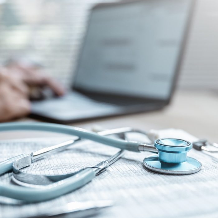 Health insurance concept. Healthcare and medical care. Life insurance policy. Medicine, Hospital, Stethoscope, Doctor. Patient business. Healthcare expense. A person is typing with a stethoscope.