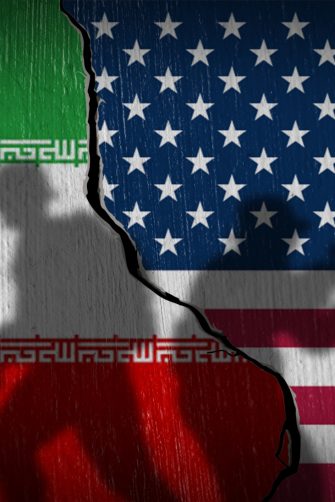 National flags of USA and Iran on a cracked stone wall with soldier silhouettes. Concept of Middle East tension and nuclear war.