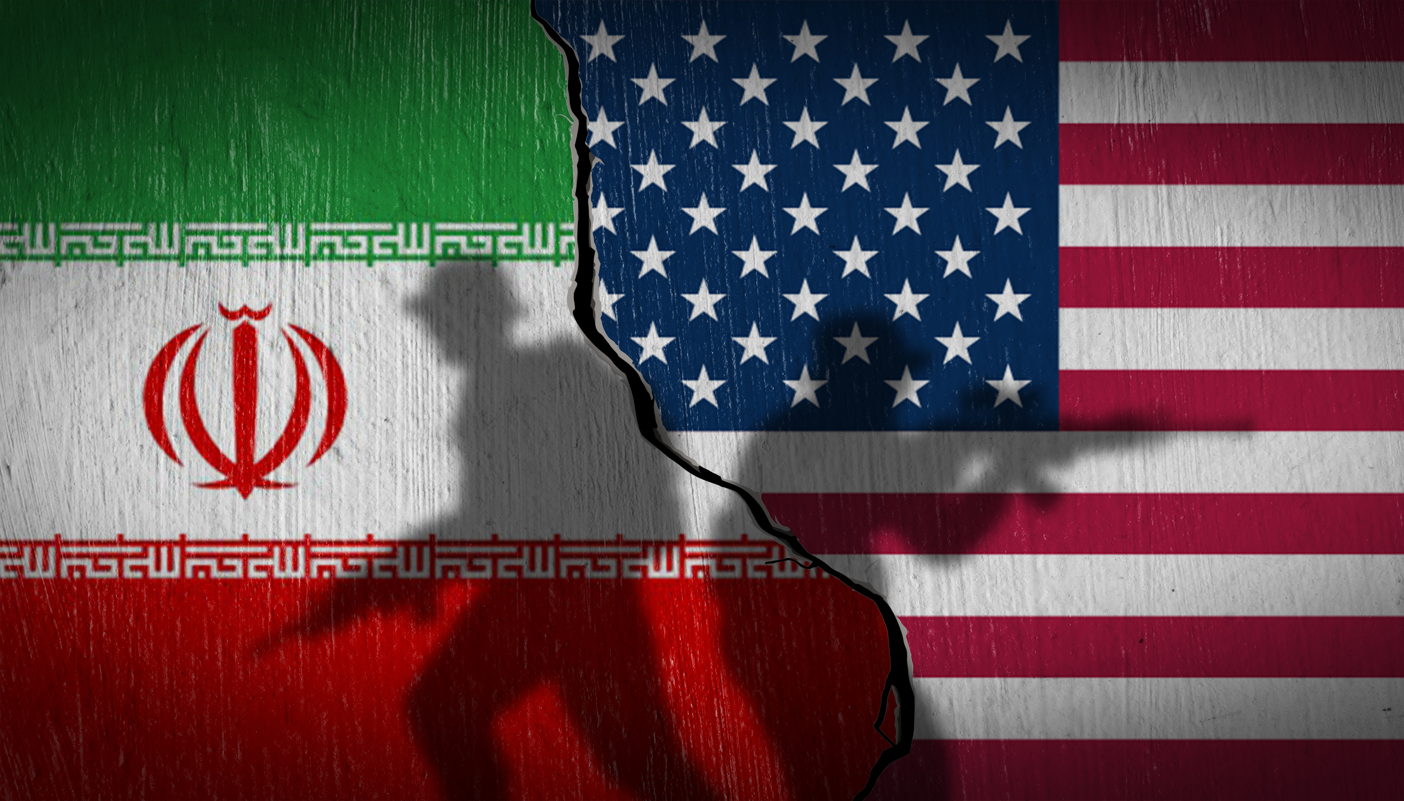 National flags of USA and Iran on a cracked stone wall with soldier silhouettes. Concept of Middle East tension and nuclear war.