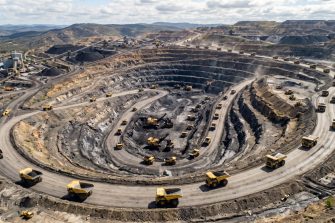 Trucks line up to take loads of coal in an open cut mine