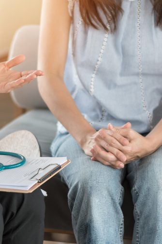 Patient couple consulting with doctor or psychologist on marriage counseling, family medical healthcare therapy, In vitro fertility IVF treatment for infertility, or psychotherapy session concept