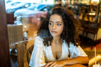 Depressed sad latin woman in bakery. Looking at the horizon, worried. end of relationship.