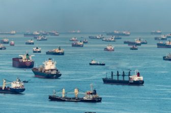 Lots of freight ships in some body of water somewhere