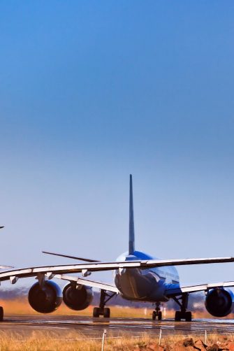5 commercial airplanes lining up on runway of airport airfield waiting for departure. Clear sky above Sydney International airport and land jet traffic.
