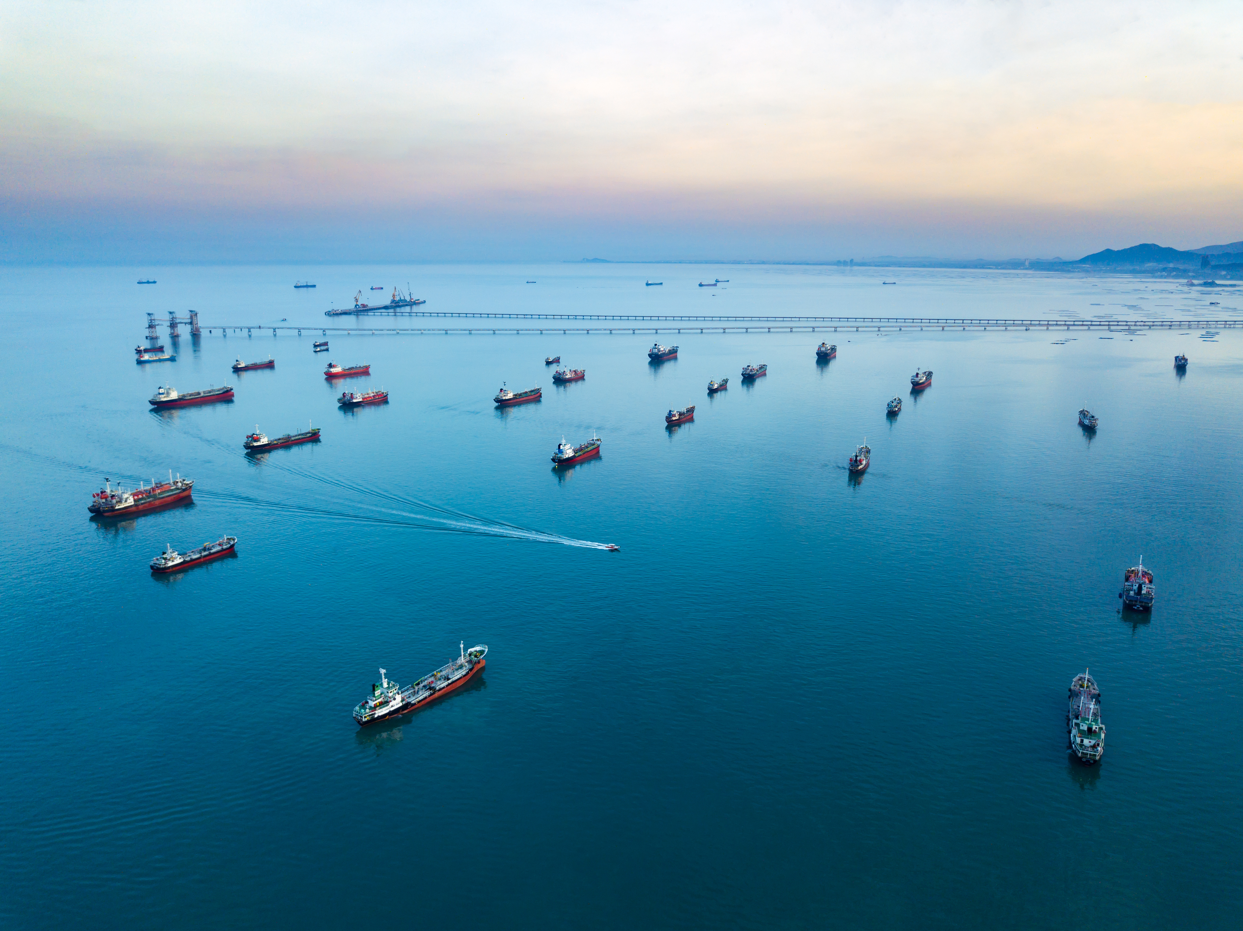 Aerial view from drone, Oil tanker ships off the coast in beautiful light sundown, professional business logistics and transportation of energy fuels.