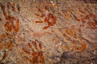 Ochre Hands, Red, Orange, Yellow hand prints on rock, Aboriginal art in Queensland, Australia.
