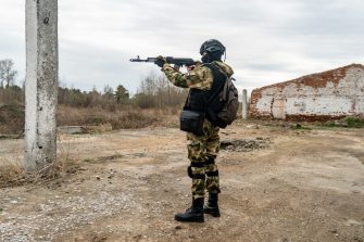 Russian assault military forces soldiers at combat action. A Russian special forces soldier holds Kalashnikov assault rifle in his hands and stands in the sight. military exercises in Russia army.