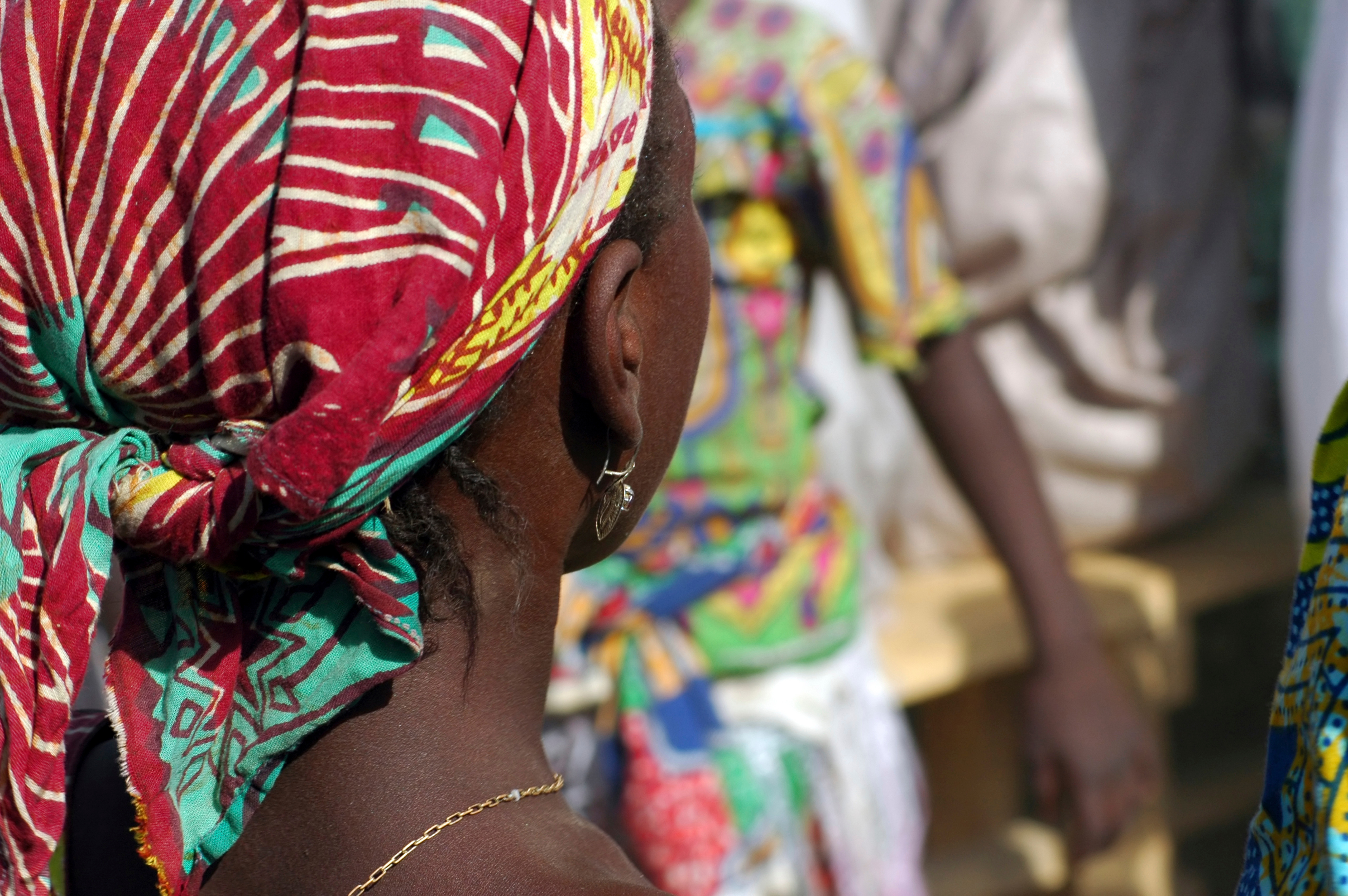 CAMEROON, Maga. Back of the head of an african young girl, her head covered with colourful red and green pattern african traditional cloth.