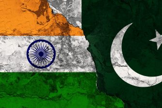 Concept of a Conflict between India and Pakistan with painted flags on a wall with a crack