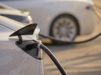 Electric cars charging at charging station outdoors at sunset.