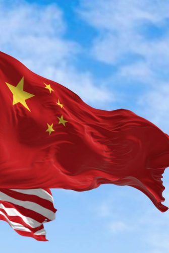 National flags of China and the United States waving in the wind on a clear day. International relationship. 3d illustration render. Selective focus.