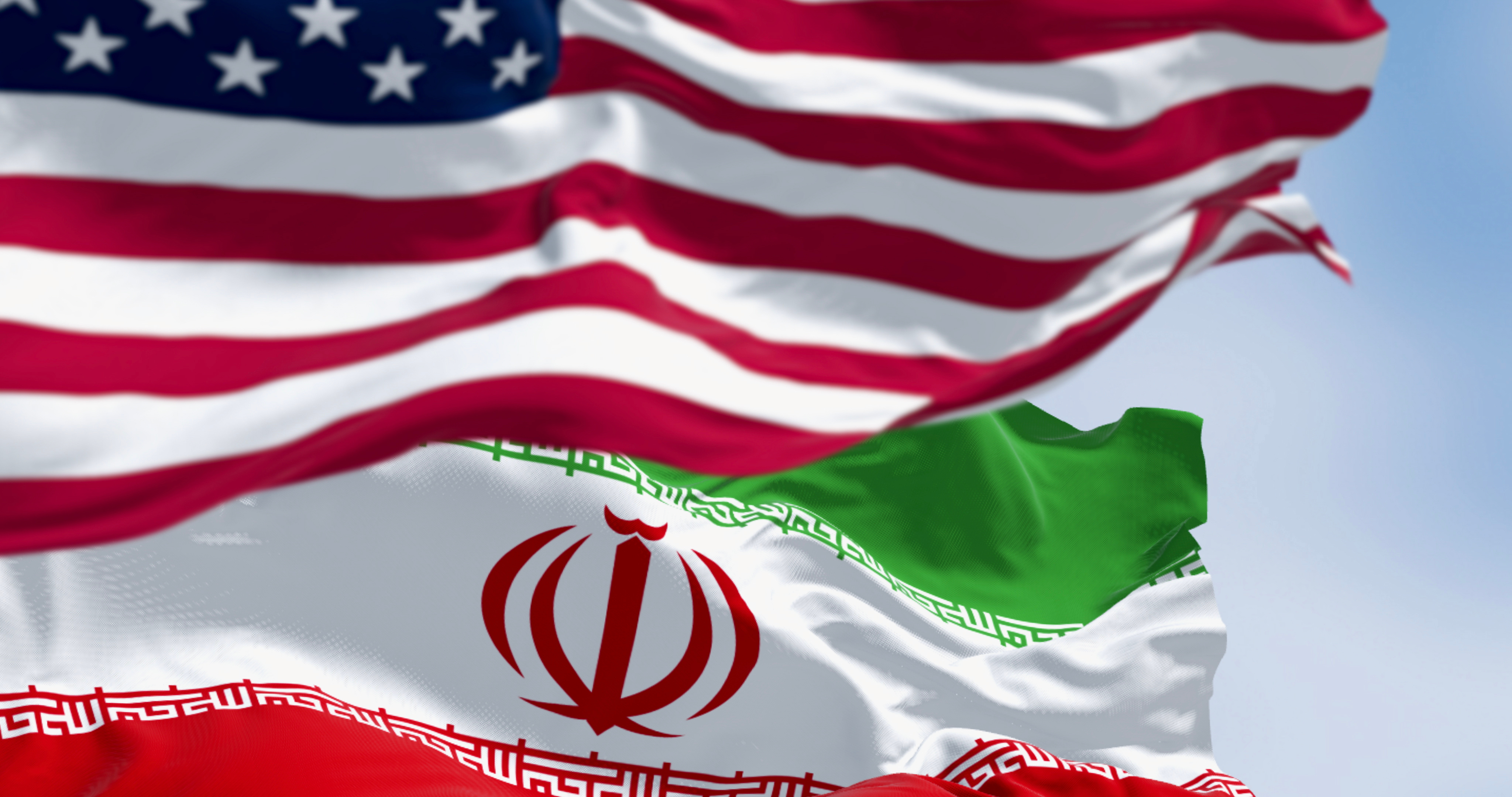 USA and Iran flags waving together