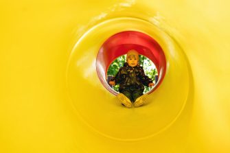 A little girl inside a tube slide on playground