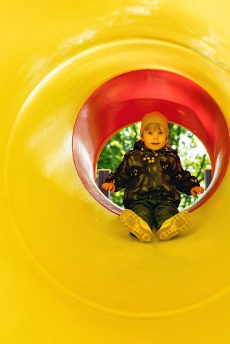 A little girl inside a tube slide on playground