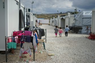 Children walking in a Syrian refugee camp in the outskirts of Athens